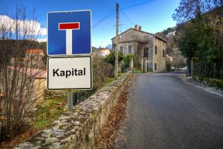 Verkehrsschild mit Aufschrift Kapital neben einer Straße